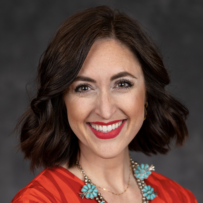 professional woman with chin-length dark brown hair smiles at camera